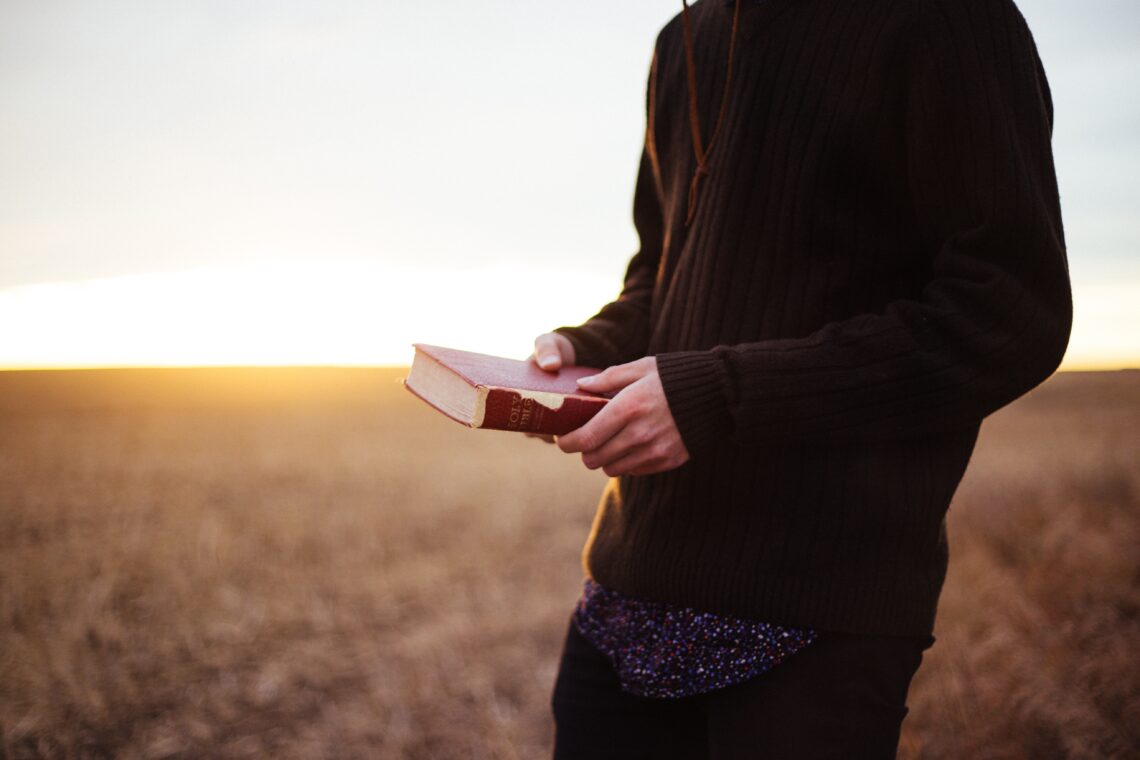 Man in field with Bible
